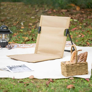 Verstellbare, beige Strandmatte mit schwarzer StĂĽtze in einem Beispiel auf einer Wiese