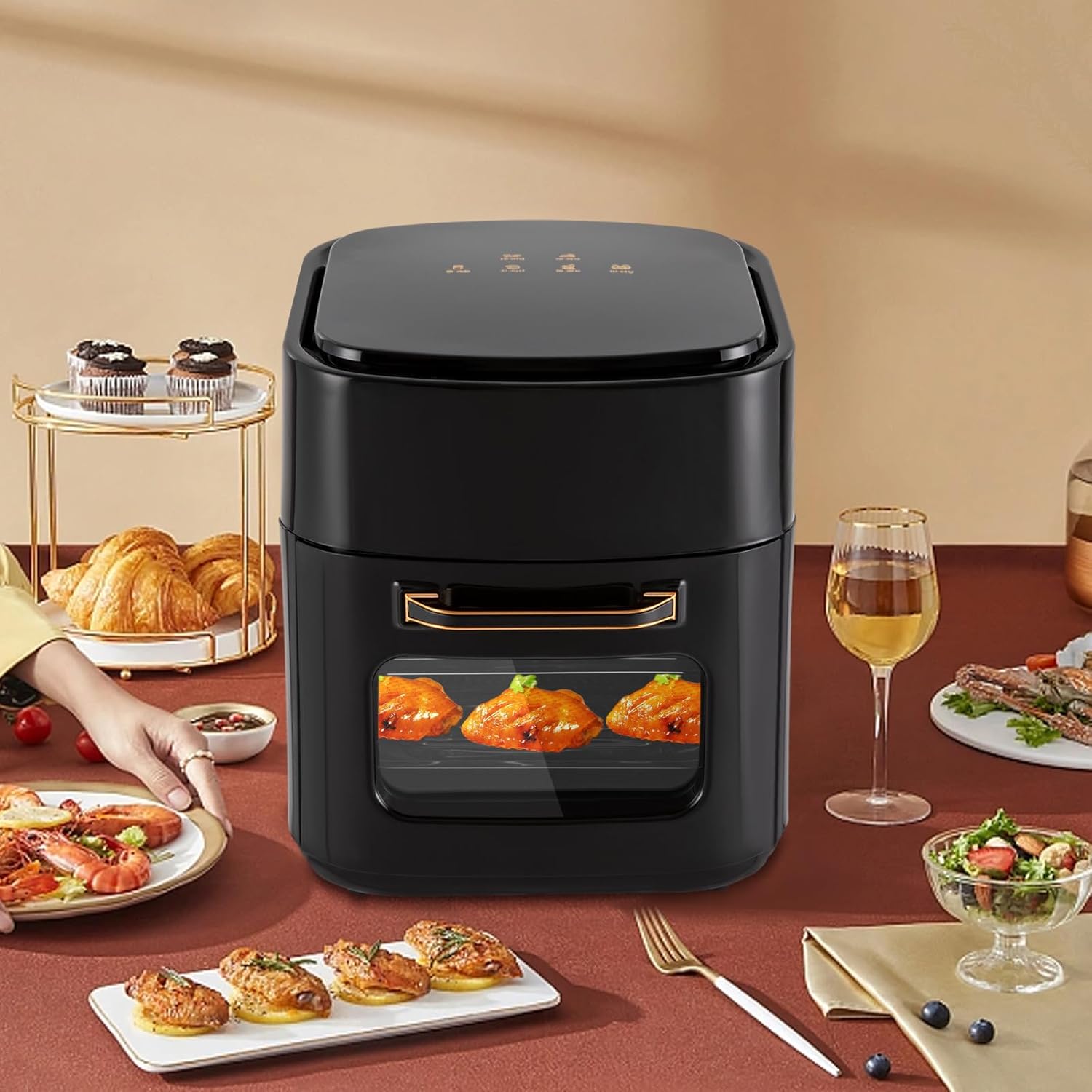 Schwarzer Airfryer mit Sichtfenster, darin Beispielsgericht, auf gedecktem Tisch