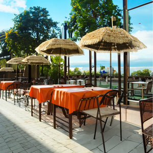 Parasol beige avec pied en bois de style hawaïen, dans un exemple d’utilisation dans un restaurant