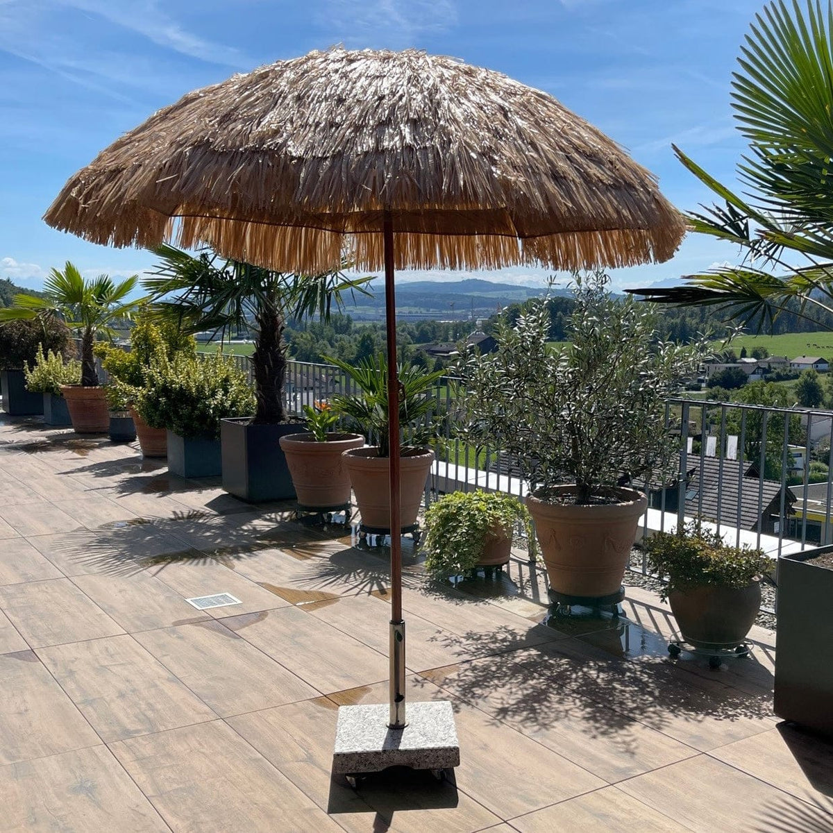 Parasol beige avec pied en bois de style hawaïen, dans un exemple d’utilisation sur une terrasse