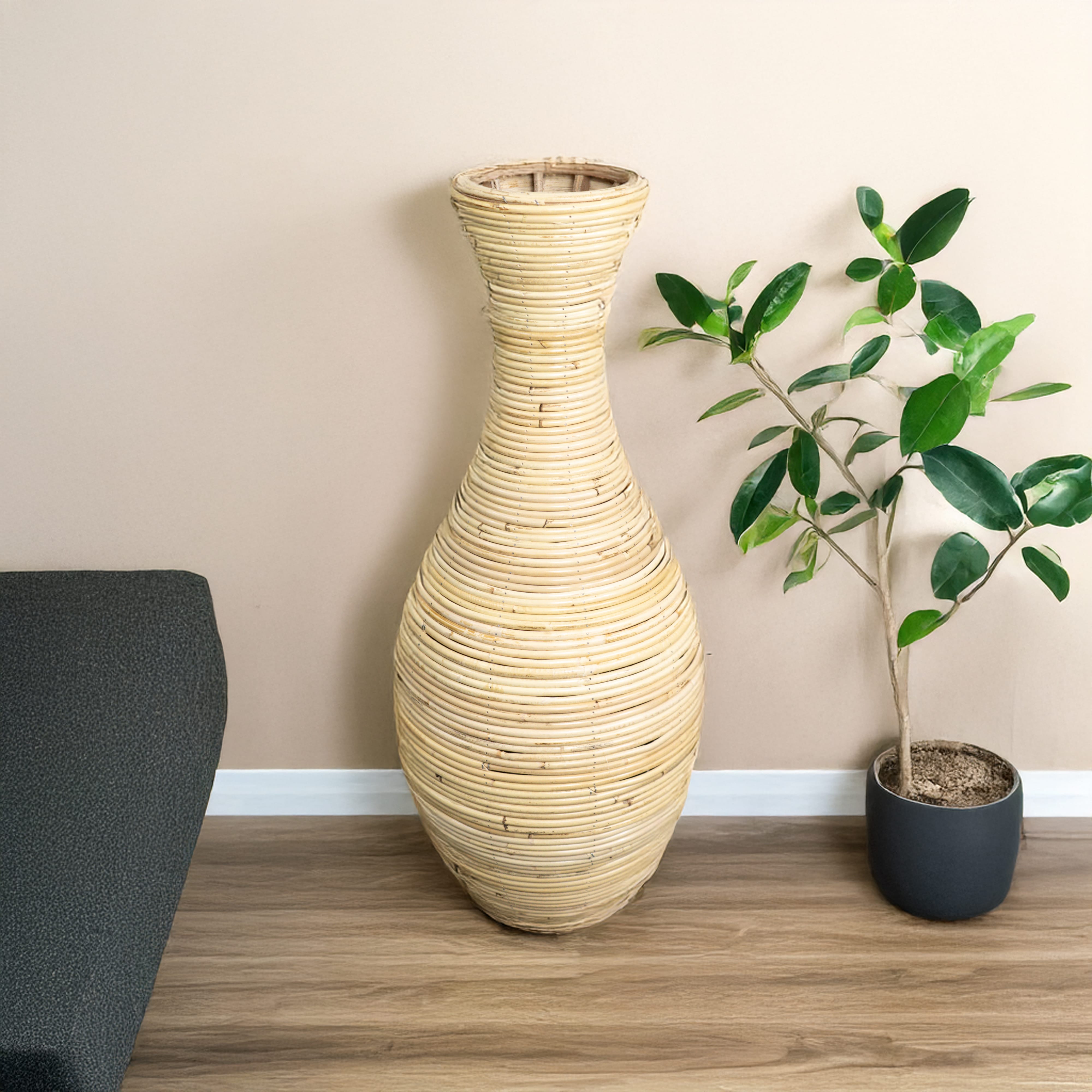 Detaillierte, beige Bodenvase, unten breit und oben dünn in einem zweiten Anwendungsbeispiel mit beiger Wand im Hintergrund